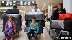 FILE - The al-Qassab family, Iraqi Christian refugees from Mosul, waits at the Beirut International Airport ahead of their travel to the United States, in Lebanon, Feb. 8, 2017.