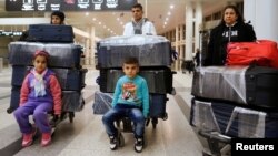 FILE - The al-Qassab family, Iraqi Christian refugees from Mosul, at Beirut international airport ahead of their travel to the United States, Lebanon, Feb. 8, 2017.