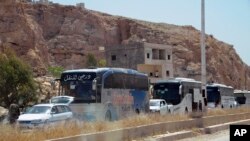 This photo from the Syrian official news agency shows buses carrying Syrian citizens who were evacuated from Damascus' besieged northeastern Barzeh neighborhood, May 8, 2017.