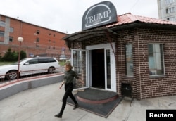 A visitor walks out of Trump Burger, a new Russian diner named after U.S. President Donald Trump, with a detention centre seen in the background, in Krasnoyarsk, Russia July 17, 2018.