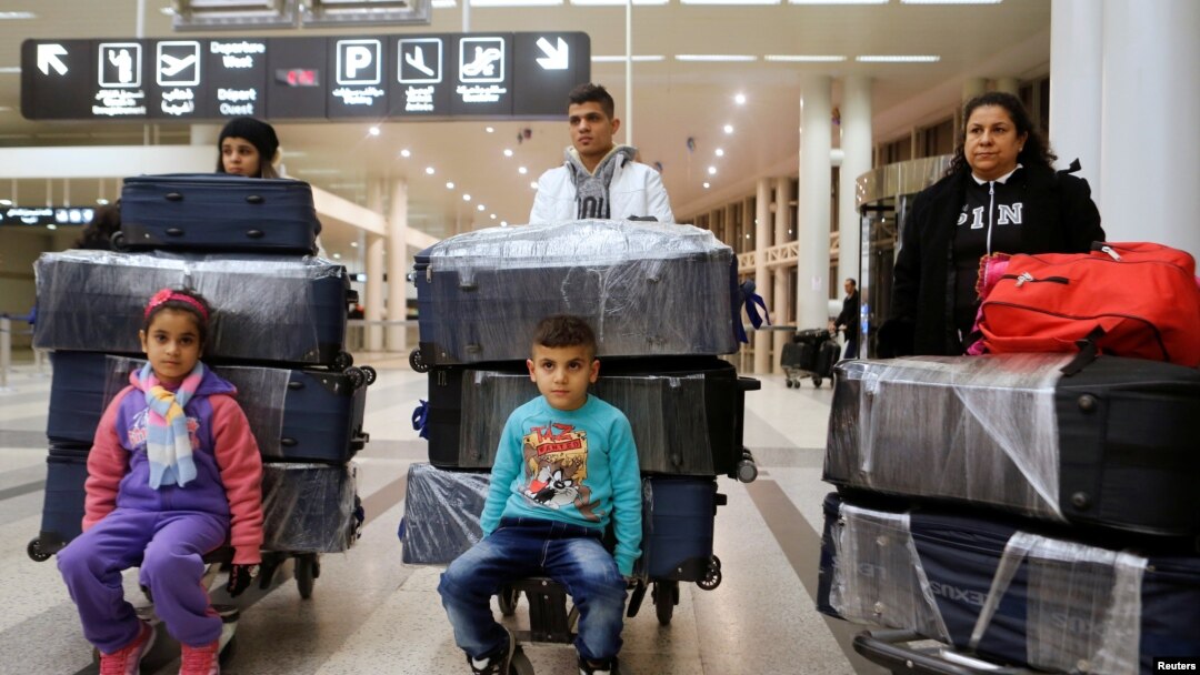 FILE - The al-Qassab family, Iraqi Christian refugees from Mosul, walk through the Beirut international airport ahead of their travel to the United States, in Beirut, Lebanon, Feb. 8, 2017.