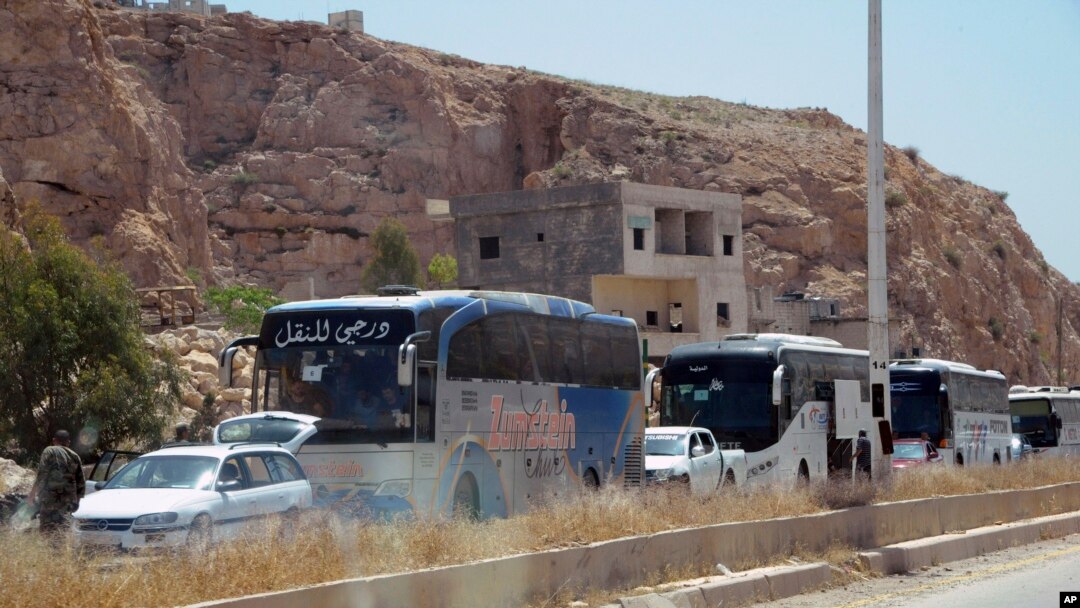 This photo from the Syrian official news agency shows buses carrying Syrian citizens who were evacuated from Damascus' besieged northeastern Barzeh neighborhood, May 8, 2017.