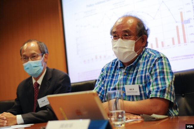香港民意研究所副总裁钟剑华(右一)表示,港府未处理根源问题,难以引起公众好感。(美国之音王四维拍摄)