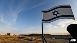 FILE - An Israeli flag stands by a road near the Israeli settlement of Shlomtzion in the Jordan valley of the occupied West Bank, Jan. 27, 2020.