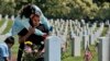 Carla Martinez comforts her cousin Ceaser Martinez as he weeps over his brother&#39;s grave on Memorial Day at the Veterans National Cemetery in Los Angeles. Rodrigo Matinez was killed in action in Iraq in 2004.