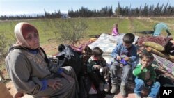 Hassana Abu Firasl, left, a Syrian woman who fled from the Syrian town of Qusair near Homs, is seen with her family at the Lebanese-Syrian border village of Qaa, eastern Lebanon, Monday, March 5, 2012. 