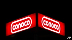 FILE - A Conoco sign at night in Dallas, Oct. 25, 2011. 