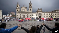 Manifestantes muestran apoyo al acuerdo de paz entre el gobierno colombiano y los rebeldes de las FARC, en la plaza principal de Bogotá, Colombia, el 8 de octubre de 2016. (Foto AP/Iván Valencia, Archivo)