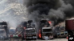 FILE - Smoke rises from NATO supply trucks following an attack by militants in Torkham, Afghanistan, Sept 2, 2013. 