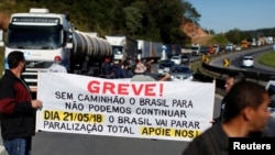 Brazilian truck drivers blocked the BR-116 highway with their trucks during a strike in Curitiba, Brazil, May 21, 2018. The banner reads: "Strike! Without truck, Brazil stop, we can not continue. Brazil will stop, total stoppage, support us!"