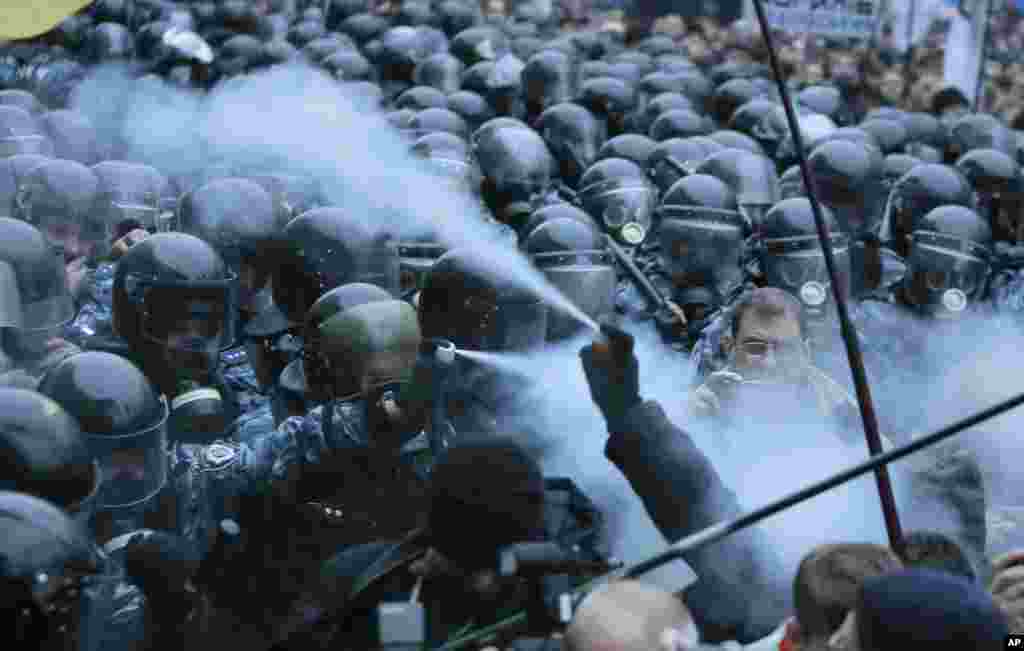 Opposition protesters and riot police spray tear gas against each other in front of the Ukrainian Cabinet of Ministers in Kyiv. Tens of thousands of demonstrators rallied in the center of Kyiv to demand that the government reverse course and sign a landmark agreement with the European Union in defiance of Russia.