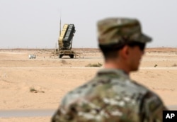 FILE - A member of the U.S. Air Force stands near a Patriot missile battery at the Prince Sultan air base in al-Kharj, central Saudi Arabia, Feb. 20, 2020.