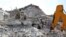 Members of the Syrian Civil Defense (White Helmets) search for victims amidst the rubble of a building that collapsed during reported airstrikes by pro-regime forces in the village of Beinin in the northern Idlib province, Aug. 20, 2019. 