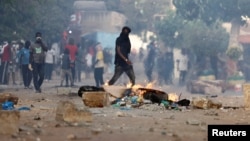 FILE: A supporter of Senegal opposition leader Ousmane Sonko walks near a burning barricade during clashes with security forces after Sonko was sentenced to prison, in Dakar, Senegal, on June 3, 2023.