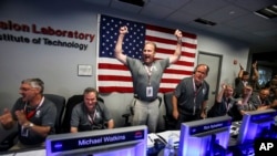 From left to right, Geoffrey Yoder, Michael Watkins, Rick Nybakken, Richard Cook and Jan Chodas celebrate in Mission Control at NASA's Jet Propulsion Laboratory as the solar-powered Juno spacecraft goes into orbit around Jupiter on Monday, July 4, 2016.