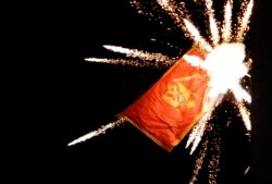 FILE - The Montenegrin flag at the Montenegrin Embassy is targeted with fireworks by Serbian ultranationalists during a protest against a religious-rights law adopted by Montenegro's parliament last month, in Belgrade, Serbia, Jan. 2, 2020.