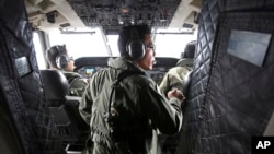 Pilots of a Royal Malaysian Air Force CN-235 aircraft manage their plane during a search and rescue operation for the missing Malaysia Airlines plane over the waters at Malacca straits, Malaysia, March 13, 2014. 