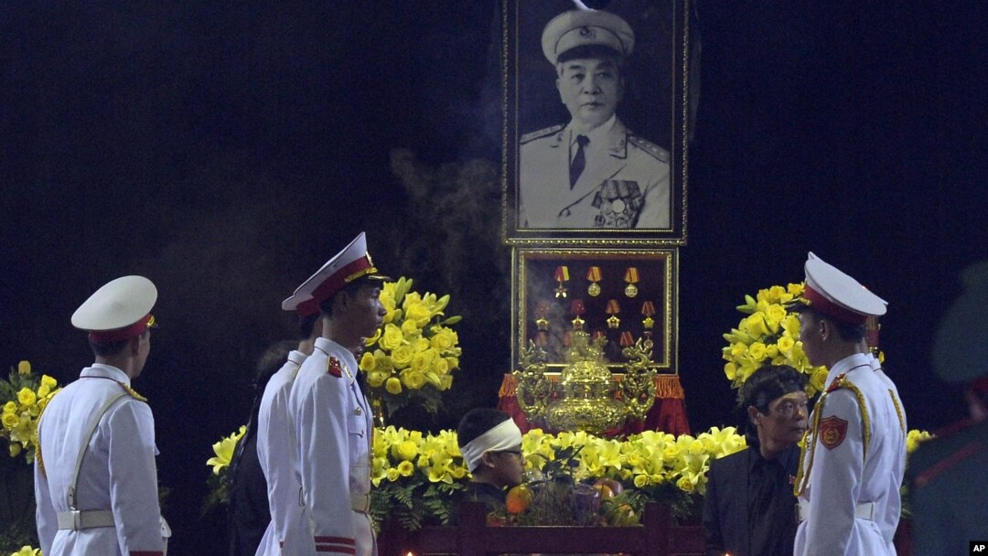 Vo Dien Bien (nomor dua dari kanan, berpakaian hitam), anak laki-laki Jenderal Vo Nguyen Giap dan pasukan kehormatan berdiri di dekat peti jenazah Giap di Tempat Persemayaman Nasional di Hanoi, Vietnam (12/10).