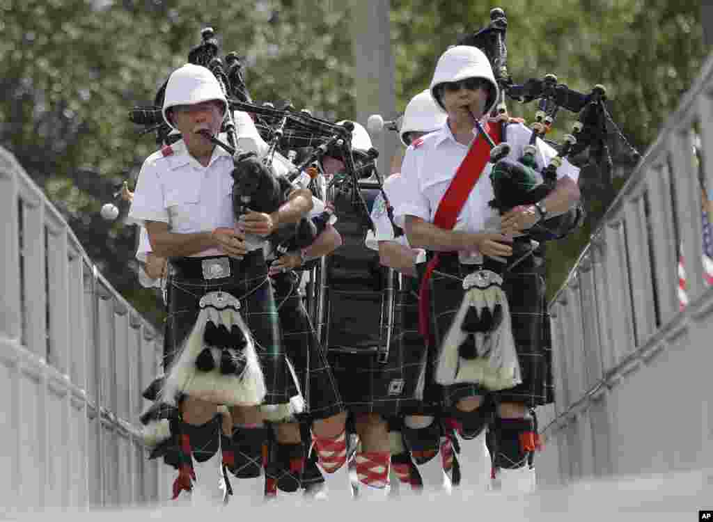 Robert Ritchie, (esq) e Nigel MacDonald (dir) Marcham com a banda de gaita de foles de Santo André de Miami durante um evento no Dia da Memória na Praia de Miami Norte, Florida, EUA.