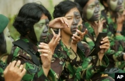 Tentara perempuan sedang memakai kamuflase untuk bersiap mengikuti parade peringatan Hari TNI ke58 di Jakarta, 22 Desember 2003