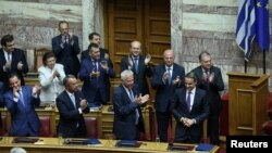 Greek Prime Minister Kyriakos Mitsotakis acknowledges applause from ministers of his government following a confidence vote on government policies in Athens, Greece, July 22, 2019. 