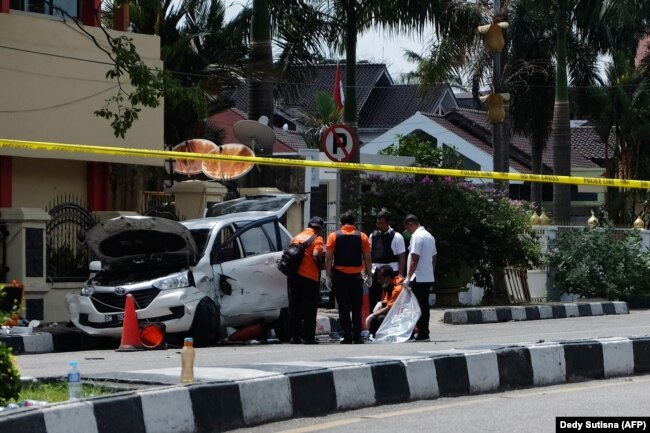 Polisi memeriksa mobil yang digunakan penyerang di luar Mapolres Pekanbaru, Riau, menyusul penyerangan pada 16 Mei 2018. (Foto: AFP/Dedy Sutisna)