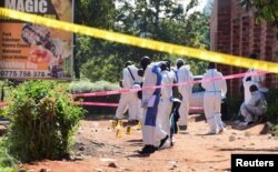 Ugandan explosives experts secure the scene of an explosion in Komamboga, a suburb on the northern outskirts of Kampala, Uganda, Oct. 24, 2021.