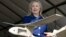 En esta foto la secretaria de Estado de EE.UU., Hillary Clinton, sostiene un drone usado en Uganda para encontrar y destruir explosivos que matan a soldados.