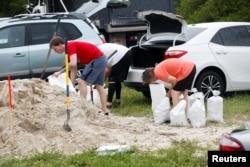 Warga menyiapkan karung pasir yang dibagikan kepada warga Pinellas County menjelang Badai Tropis Milton di Seminole, Florida, Amerika Serikat, 6 Oktober 2024. (Octavio Jones/REUTERS)