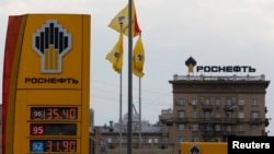 FILE - The logo of Russia's top crude producer Rosneft is seen on a price information board of a gasoline station in Moscow, July 17, 2014.
