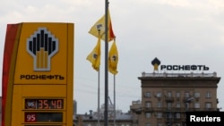 The logo of Russia's top crude producer Rosneft is seen on a price information board of a gasoline station in Moscow July 17, 2014.