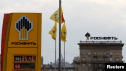 FILE - The logo of Russia's top crude producer, Rosneft, is seen on a price information board of a gasoline station in Moscow July 17, 2014.