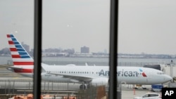 FILE - An American Airlines plane sits at a boarding gate at LaGuardia Airport, in New York, March 13, 2019. Starting April 1, 2022, U.S. jets will be able to land in Hong Kong.