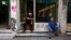 Men sit in front of a shop in central Athens, Greece, July 21, 2015. 