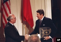 FILE - U.S. President Ronald Reagan, right, shakes hands with Soviet leader Mikhail Gorbachev after the two leaders signed the Intermediate Range Nuclear Forces Treaty, Dec. 8, 1987. (AP Photo/Bob Daugherty, File)