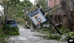 A resident walks beside a toppled basketball court after Typhoon Mangkhut barreled across Tuguegarao city, Cagayan province, northeastern Philippines, Sept. 15, 2018.
