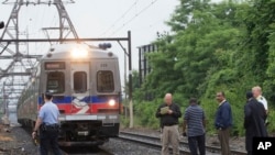 Funcionarios de la autoridad de transporte de Filadelfia observan la salida de un tren en una estación de Pensilvania.