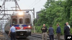 Funcionarios de la autoridad de transporte de Filadelfia observan la salida de un tren en una estación de Pensilvania.