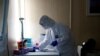 FILE - A healthcare worker works at a COVID-19 testing site as the spread of the coronavirus disease (COVID-19) continues in Budapest, Hungary, Oct. 27, 2020. 