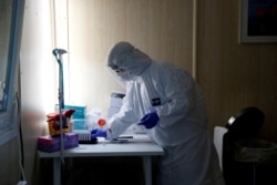 FILE - A healthcare worker works at a COVID-19 testing site as the spread of the coronavirus disease (COVID-19) continues in Budapest, Hungary, Oct. 27, 2020.