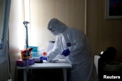 FILE - A healthcare worker works at a COVID-19 testing site as the spread of the coronavirus disease (COVID-19) continues in Budapest, Hungary, Oct. 27, 2020.