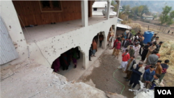 在巴基斯坦管轄的克什米爾尼勒姆山谷，當地人聚集在一座房屋附近，據他們說，這座房屋因越境砲擊而受損。 (2020年11月13日)