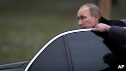 FILE - Russian President Vladimir Putin is seen getting out of his limousine in Moscow, Russia, Feb. 23, 2014.