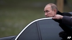 FILE - Russian President Vladimir Putin is seen getting out of his limousine in Moscow, Russia, Feb. 23, 2014.