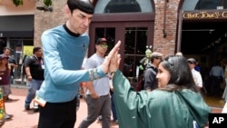 A Mr. Spock impersonator from Star Trek gives the "live long and prosper" high five to a fan at the 2015 Comic-Con International held at the San Diego Convention Center Friday, July 10, 2015 in San Diego in July 2015. (Photo by Denis Poroy/Invision/AP)