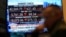 Financial news is displayed as people work on the floor at the New York Stock Exchange in New York, March 4, 2025. 