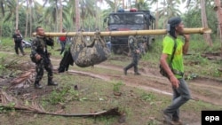 Filipino soldiers carry a recovered body in the town of Jolo, Sulu Island, southern Philippines, April 27, 2016. Authorities are working to confirm whether the headless corpse found on Jolo Island is that of Canadian hostage beheaded on April 25, 2016, by Islamist group Abu Sayyaf. 