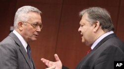 Italian Finance Minister Giulio Tremonti, left, speaks with Greek Finance Minister Evangelos Venizelos during a meeting of eurozone finance ministers at the EU Council building in Brussels, July 11, 2011