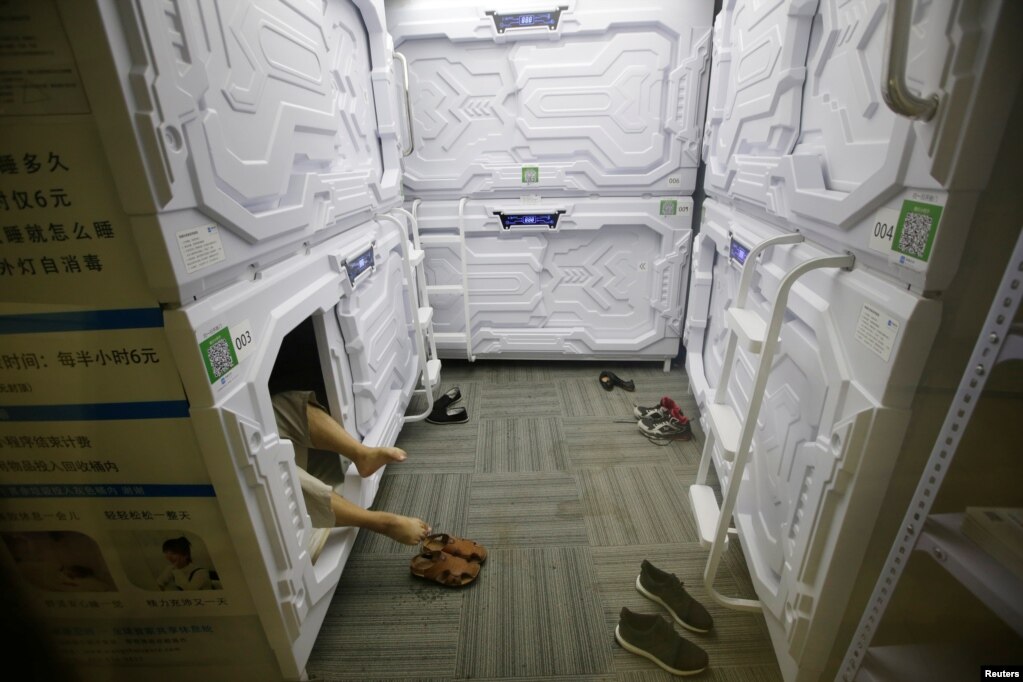 在北京中關村，一位IT產業工作人員脫鞋上床，在膠囊式的狹小的空間午睡（2017年7月11日）。