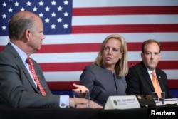 U.S. Secretary of Homeland Security Kirstjen Nielsen gestures toward U.S. Rep. Dan Donovan, R-N.Y., as she sits between Donovan and Rep. Lee Zeldin, R-N.Y., during a discussion on immigration and the gang MS-13 with U.S. President Donald Trump at the Morrelly Homeland Security Center in Bethpage, N.Y., May 23, 2018.